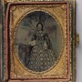 1_British-or-French.-Woman-in-patterned-dress-standing-in-front-of-painted-landscape-backdrop-1850s-1860s